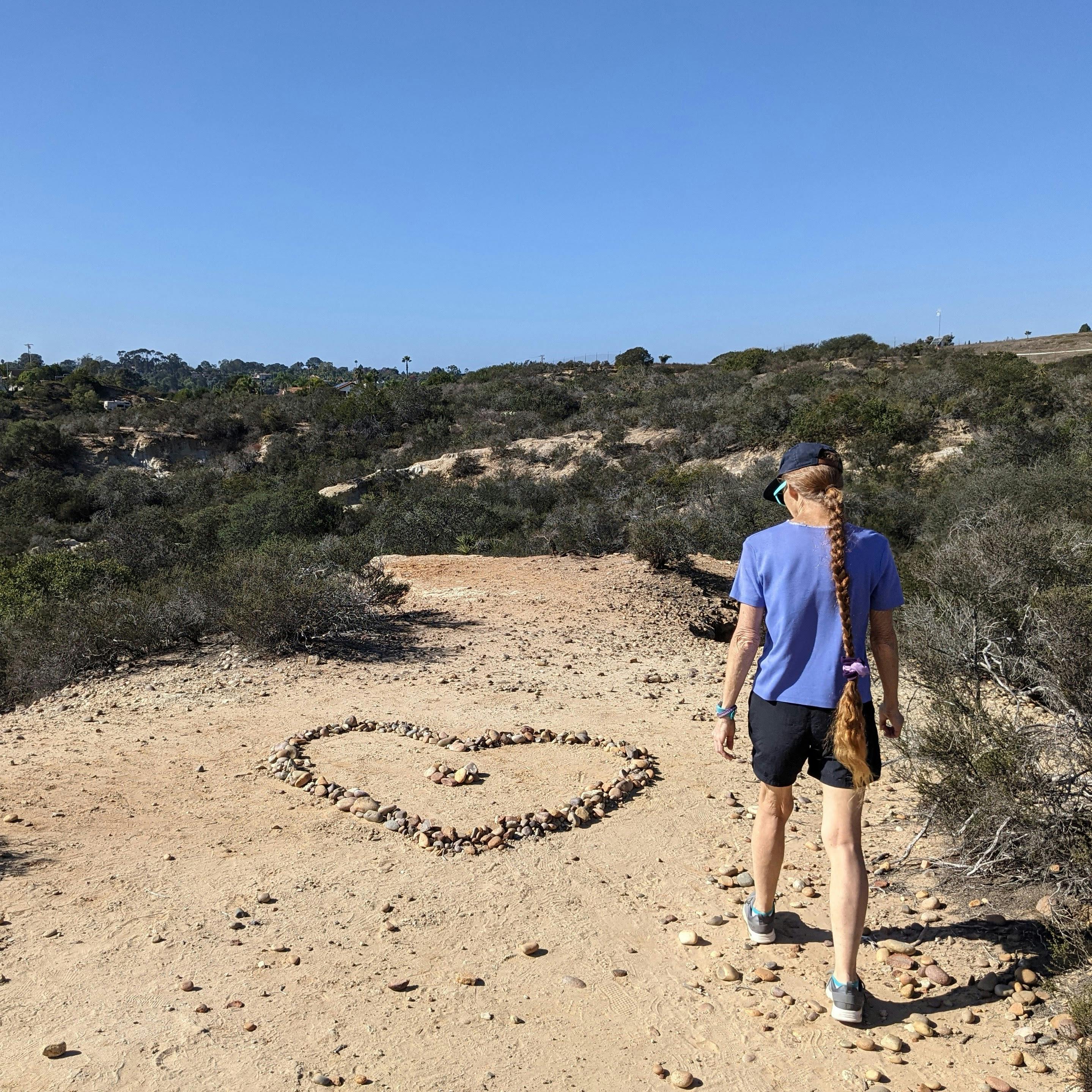 A hiker walks up to a heart shaped rock formation at Manchester Preserve in North San Diego County 