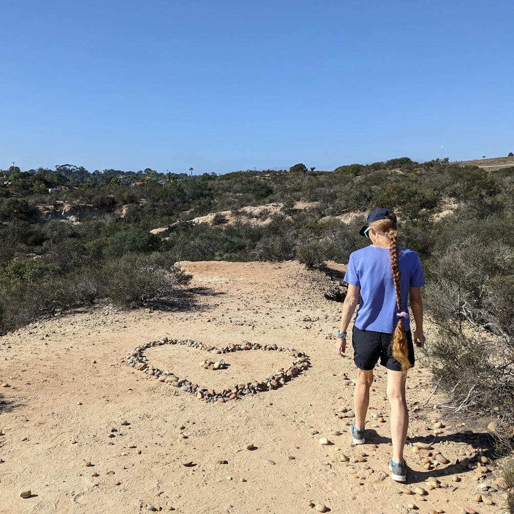 A hiker walks up to a heart shaped rock formation at Manchester Preserve in North San Diego County 