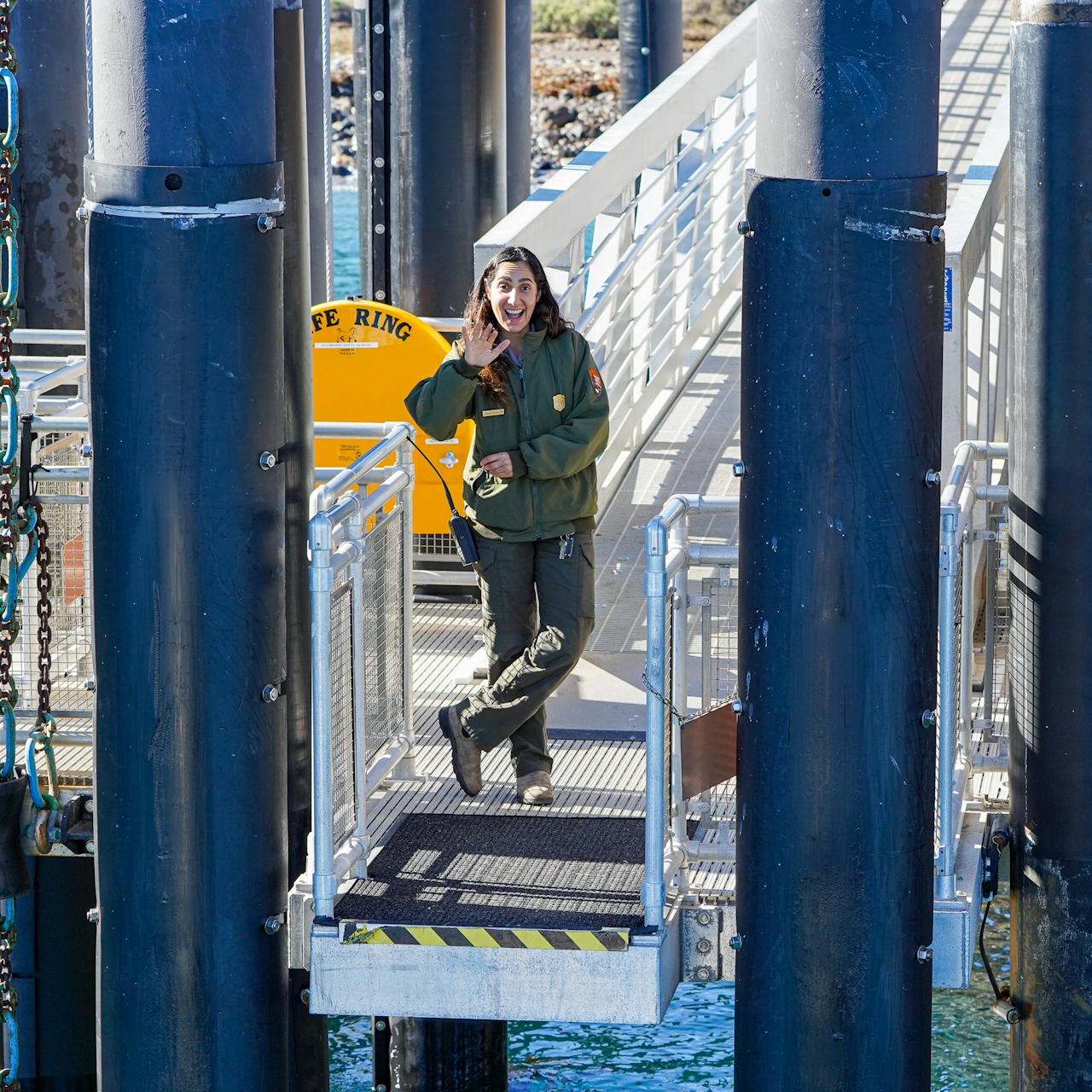 A woman waves from the dock and boat ramp at Channel Islands National Park Scorpion Anchoarge 