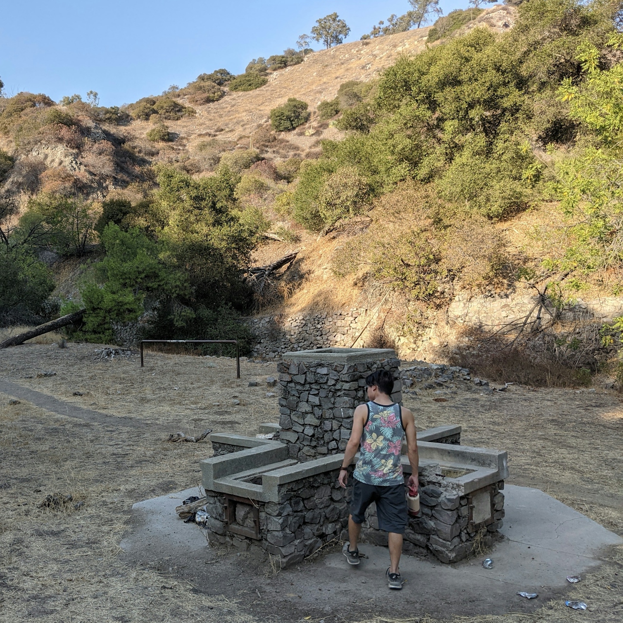 HIker looking at an old chimney remnant at Horsethief Canyon Park in San Dimas 