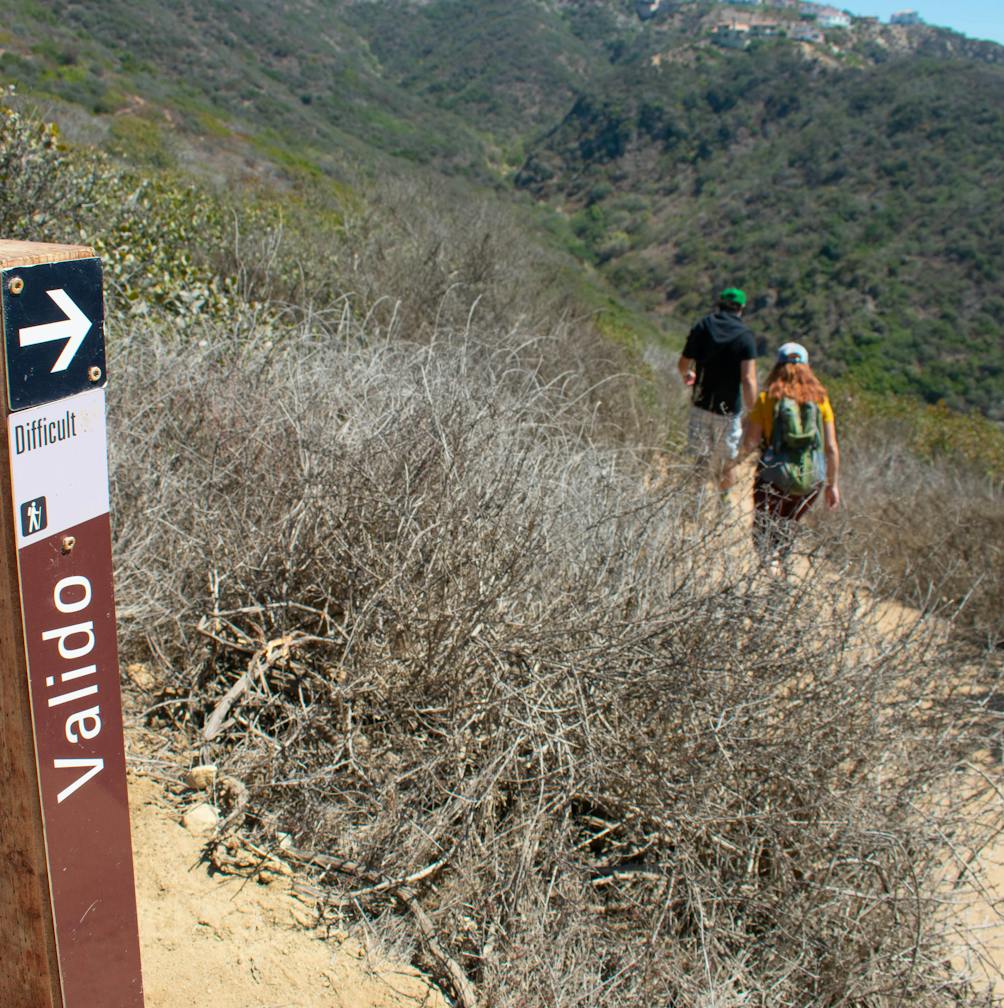 Hikers head down Valido trail towards Coast Royale Beach in Orange County 