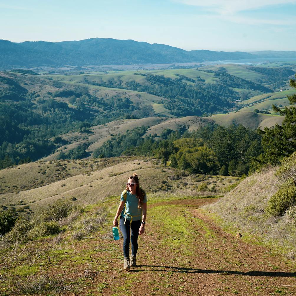 Woman hiking up Barnabe Fire Road in Samuel P Taylor State Park in Marin