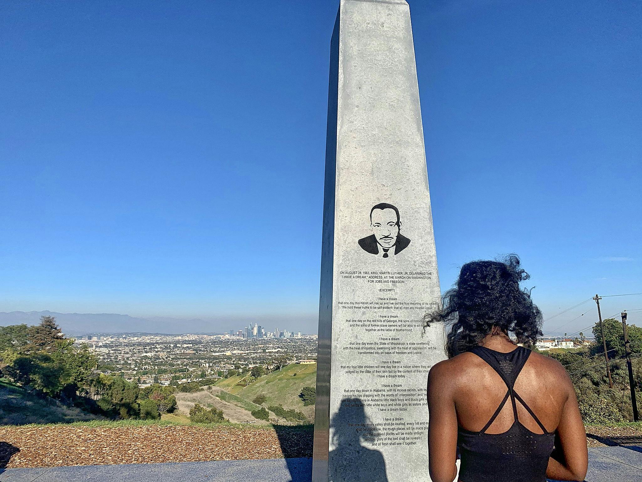 Woman standing at the Martin Luther King Jr. Memorial Tree Grove in Los Angeles 