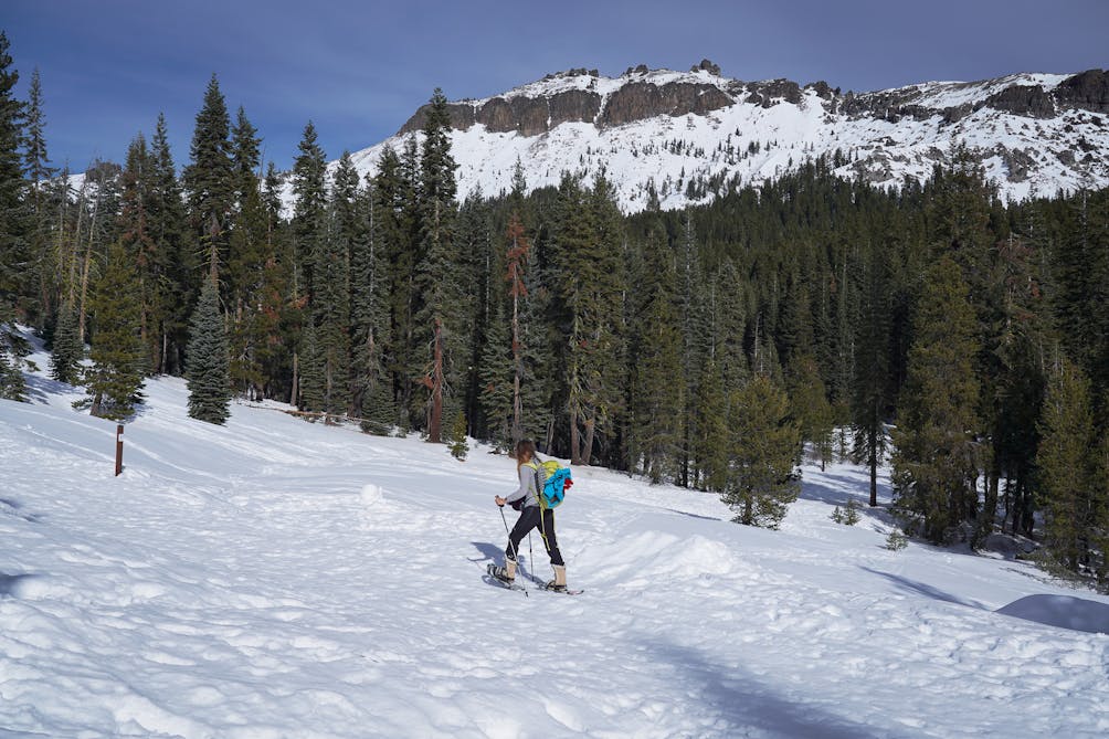 Woman snowshoe hiking up a trail to Castle Pass in Tahoe 