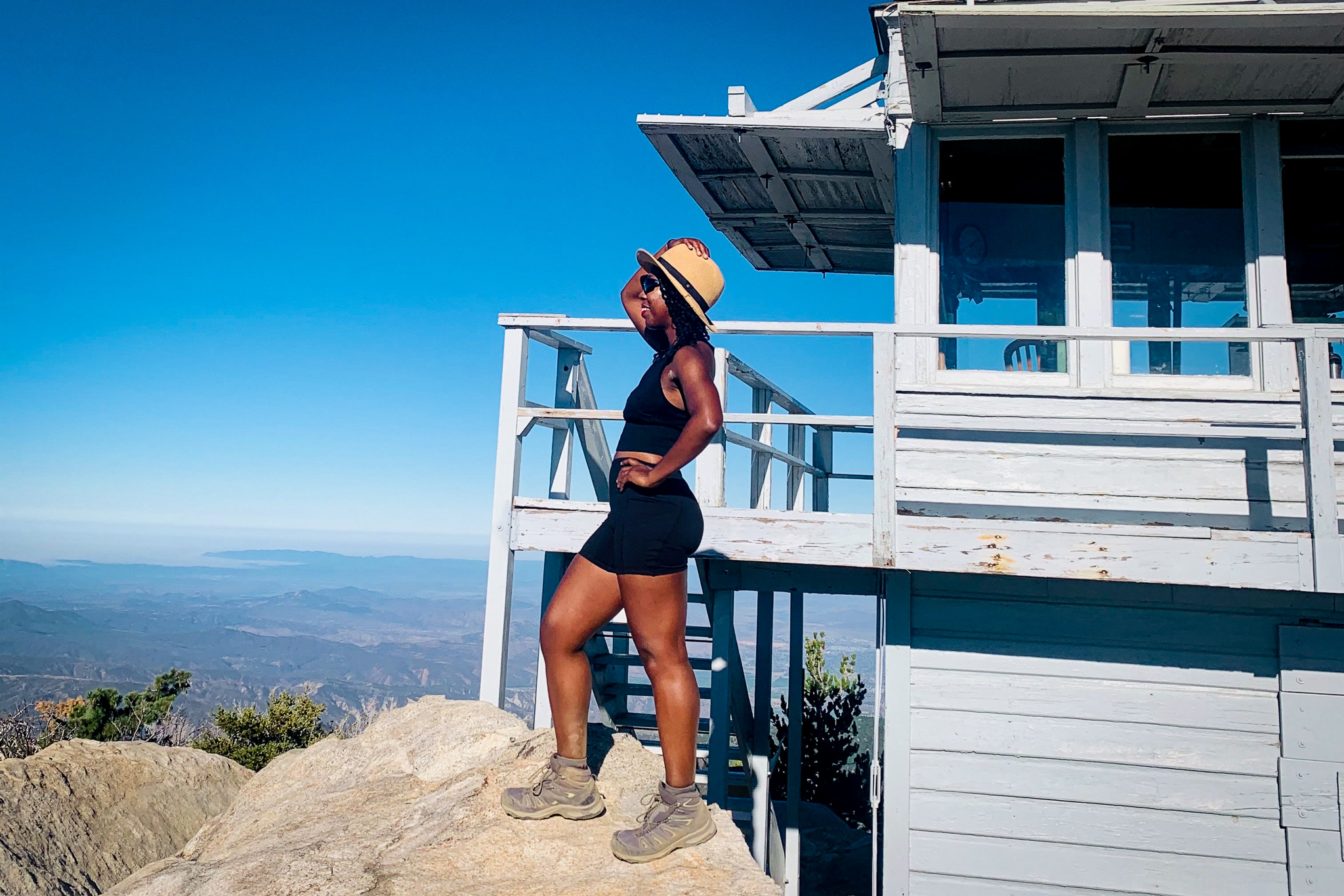 Woman standing at the lookout tower of Tahquitz Peak in the San Jacinto Wilderness in Southern California