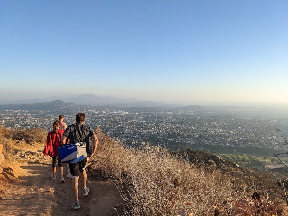 Friends walking down a hiking trail at Mount Cowles in San Diego 