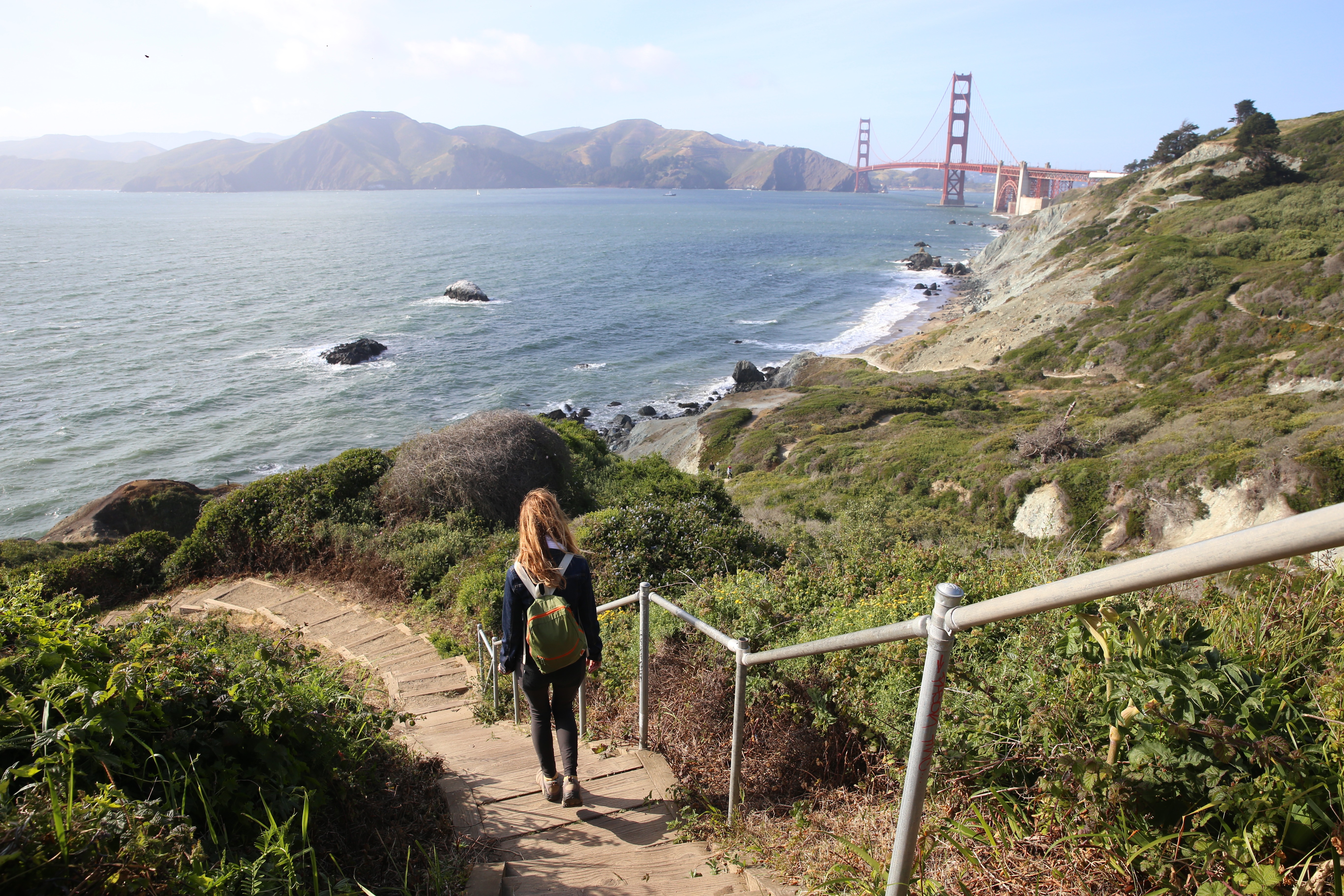 Woman walking down the stairs overlooking the ocean on the Coastal Trail in San Francisco