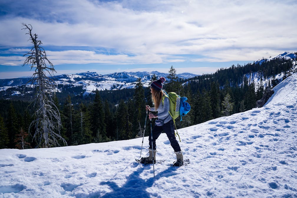 Woman snowshoeing at Castle Pass overlooking mountains in Tahoe 