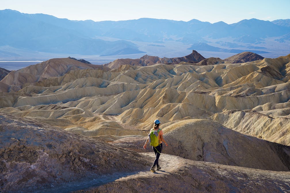 Woman hiking the Badlands Trail in Golden Canyon Death Valley National Park 