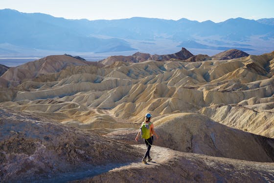 Woman hiking the Badlands Trail in Golden Canyon Death Valley National Park 