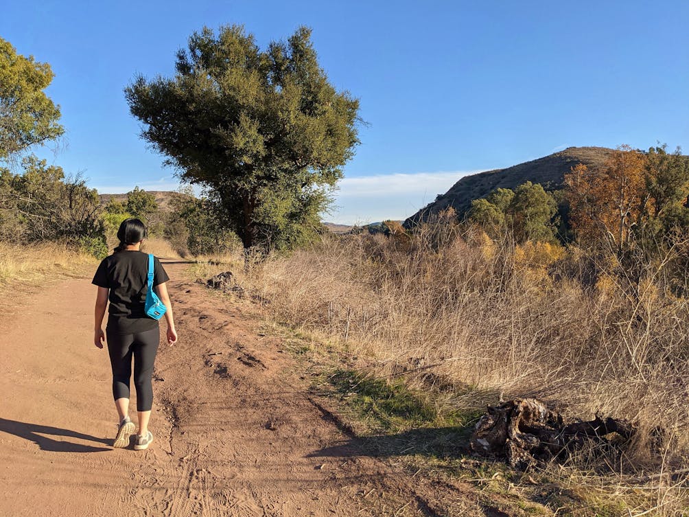 Woman hiking on a trail at Santiago Oaks Regional Park in Orange County 