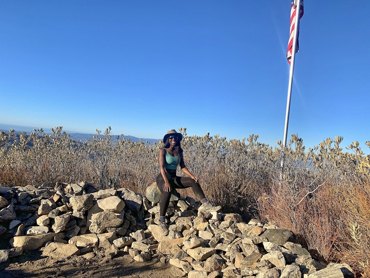 Woman sitting and smiling at the summit of Mount Lukens in Los Angeles 