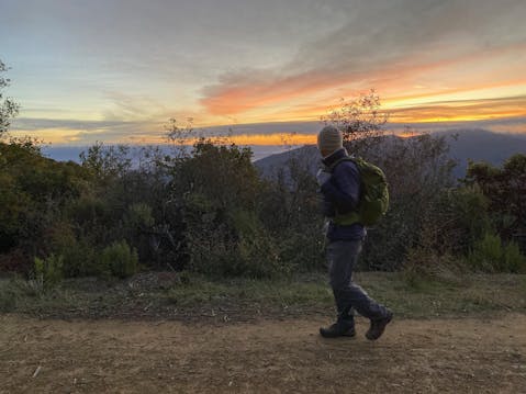 Man hiking the Aquinas Trail near sunrise in the South Bay at El Sereno Preserve 