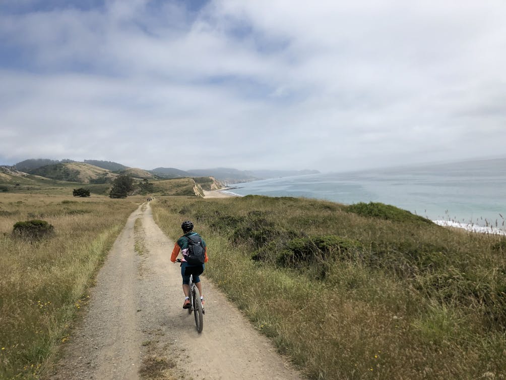 Biker on the wide open trail to Santa Maria Beach in Point Reyes National Seashore 