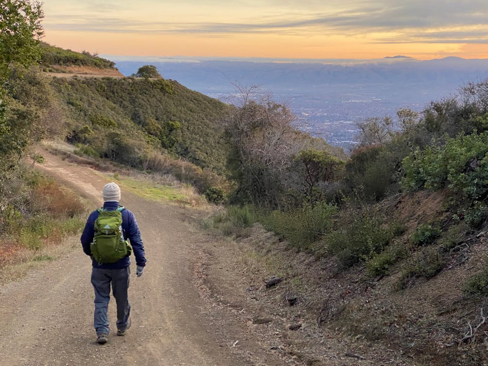 Man hiking the Aquinas Trail at sunrise in the South Bay at El Sereno Preserve