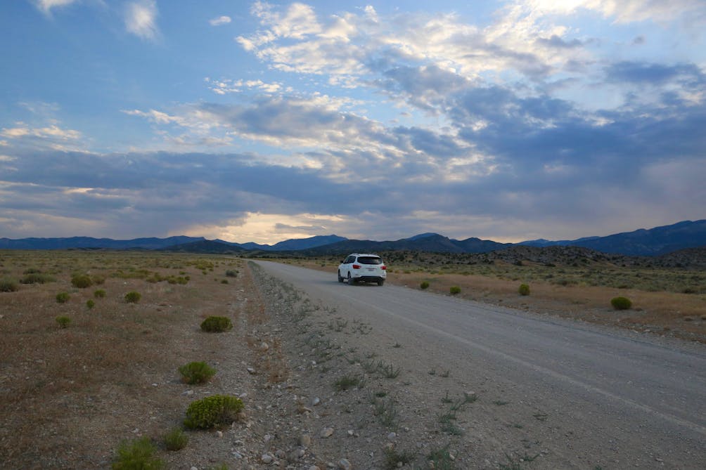 Car driving the barren highway of Nevada 