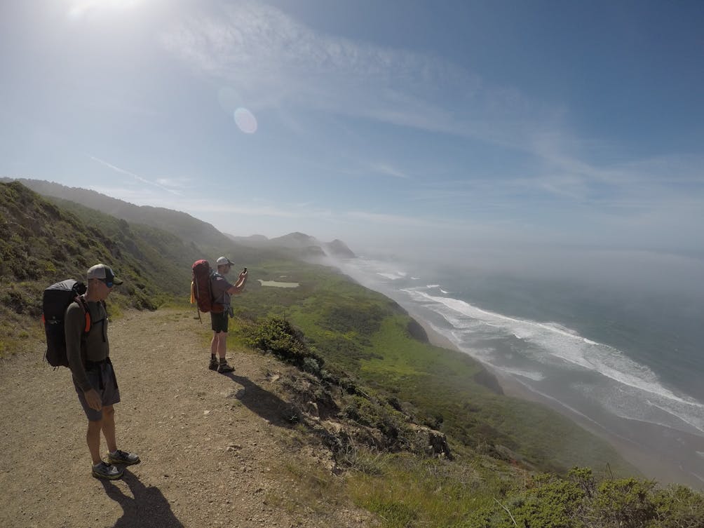 Backpackers overlooking the bluff and down to the Pacific ocean at Point Reyes National Seashore near Wildcat Camp