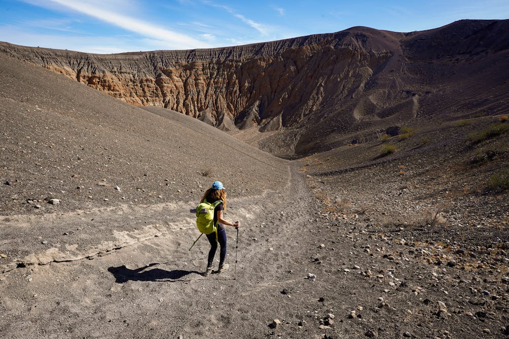 Woman hiking down a trail to Ubehebe Crater in Death Valley National Park