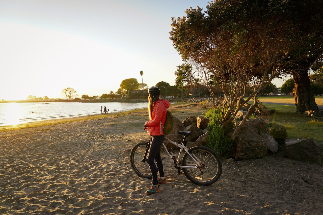 Woman on a bike at a beach in Alameda