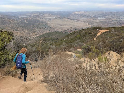 Woman hiking downhill at Kwaay Paay in Mission Trails Regional Park San Diego County 