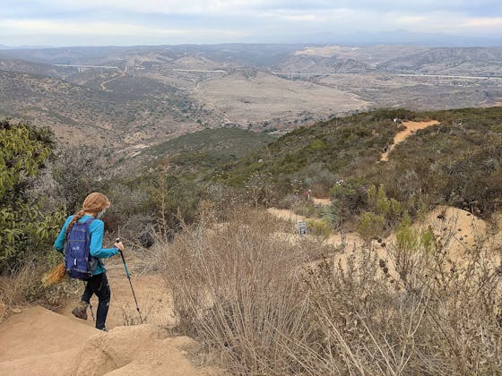 Woman hiking downhill at Kwaay Paay in Mission Trails Regional Park San Diego County 