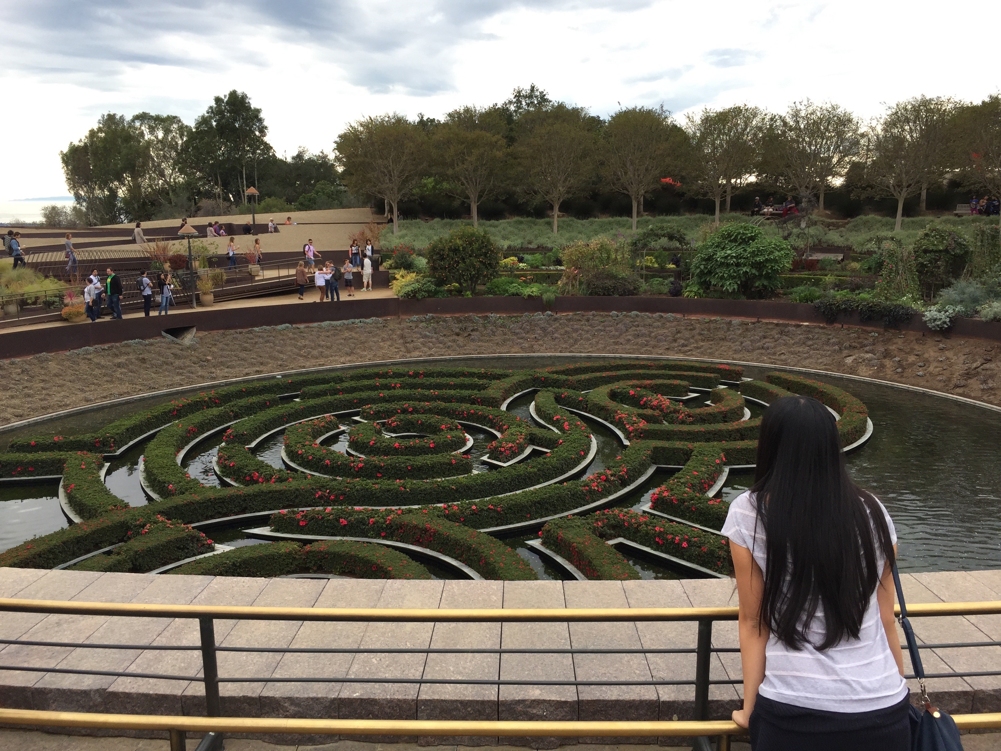 A woman stands and is overlooking the maze floating garden at the Getty Center in Los Angeles