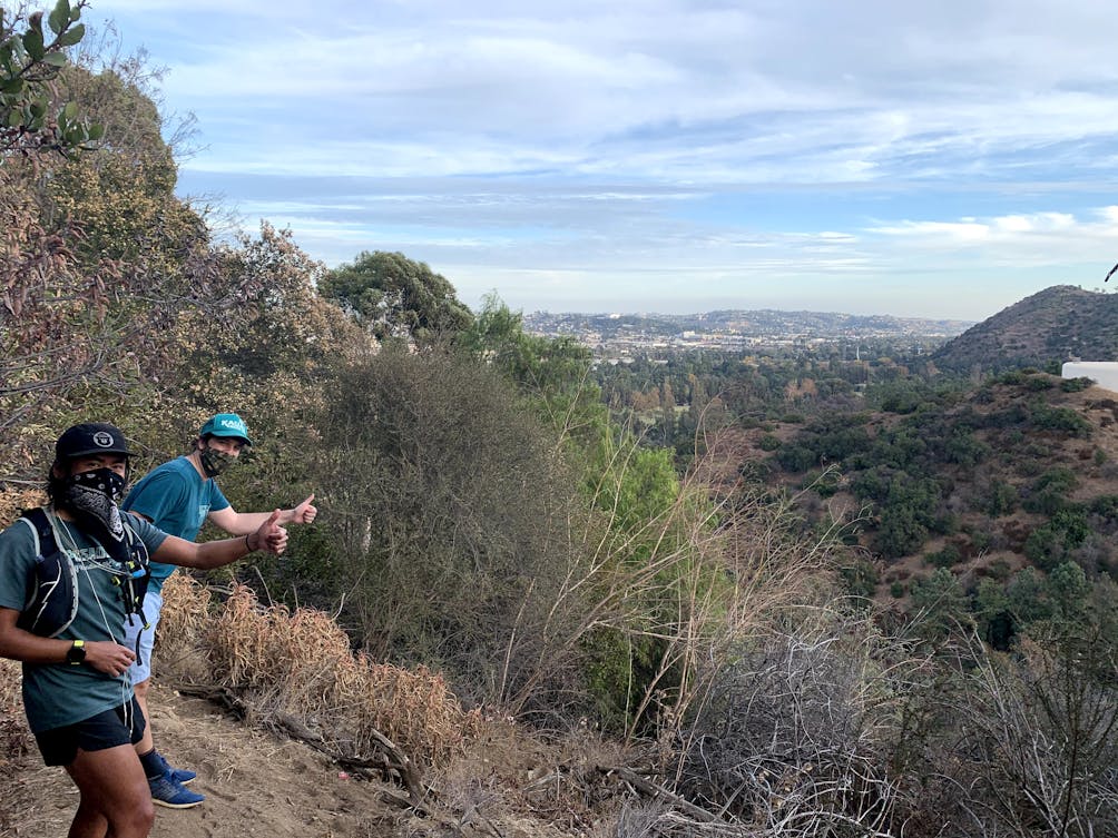 Two hikers giving the thumbs up on a hiking trail to Amir