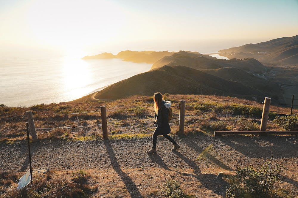 Woman walking trail overlooking the Pacific Ocean at Hawk Hill in Marin County 