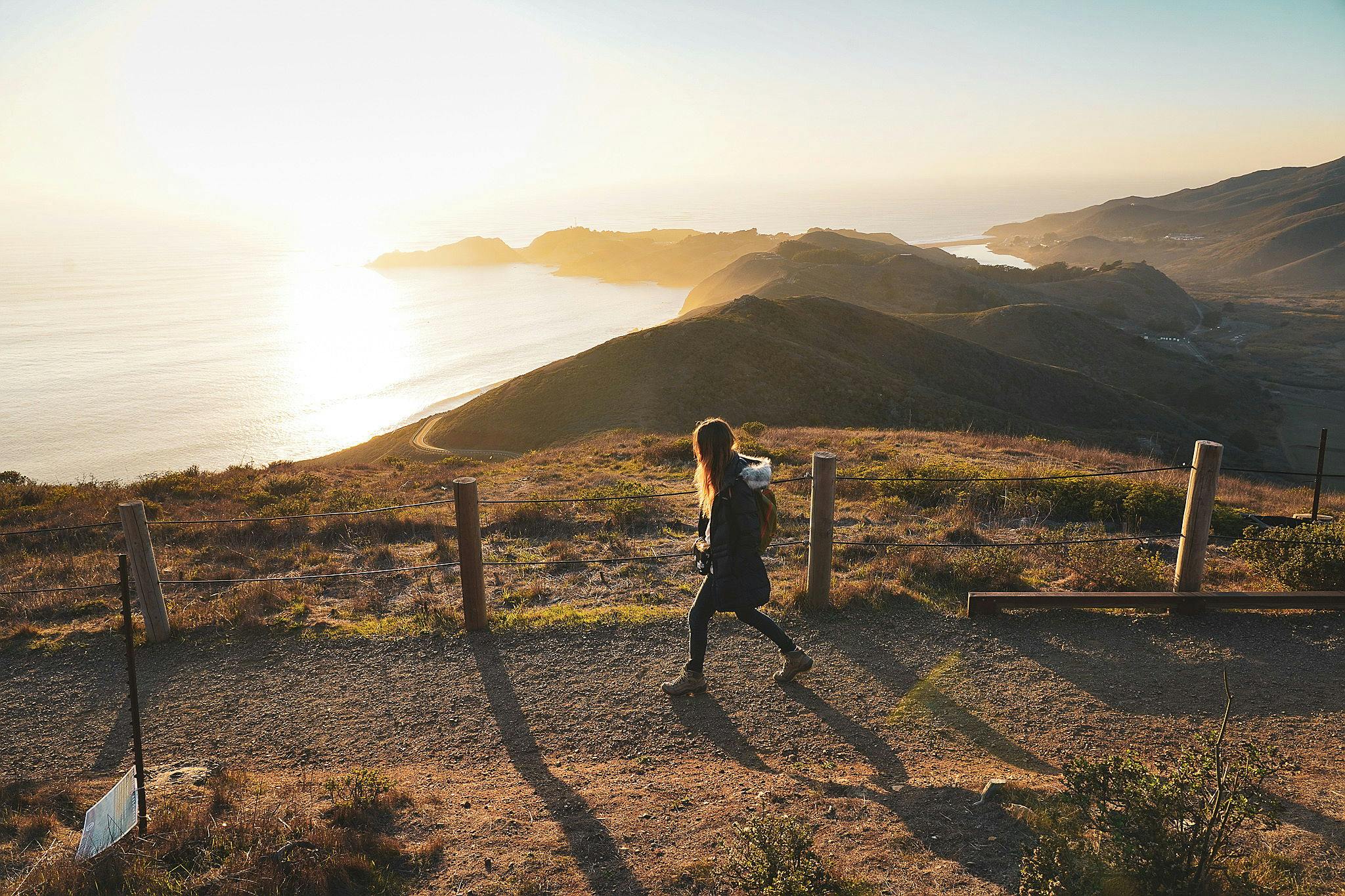 Woman walking trail overlooking the Pacific Ocean at Hawk Hill in Marin County 