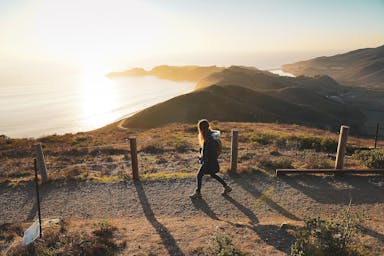 Woman walking trail overlooking the Pacific Ocean at Hawk Hill in Marin County 