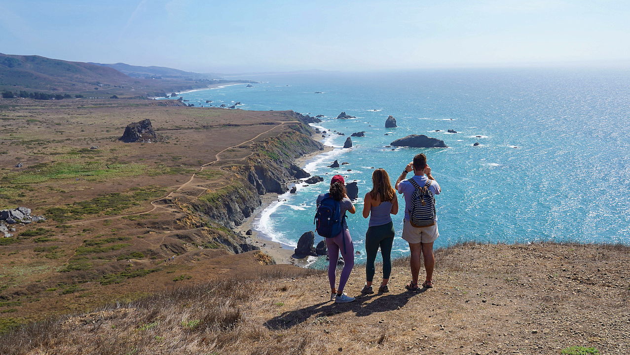 Three people standing at an overlook on the Kortum Trail in Sonoma County 