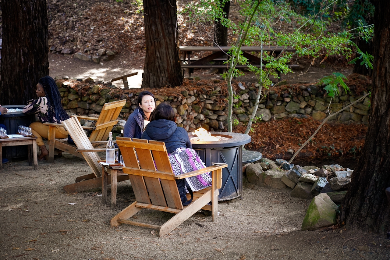 Women enjoying wine around a fire pit at Boeger Winery in Placerville Apple Hill 