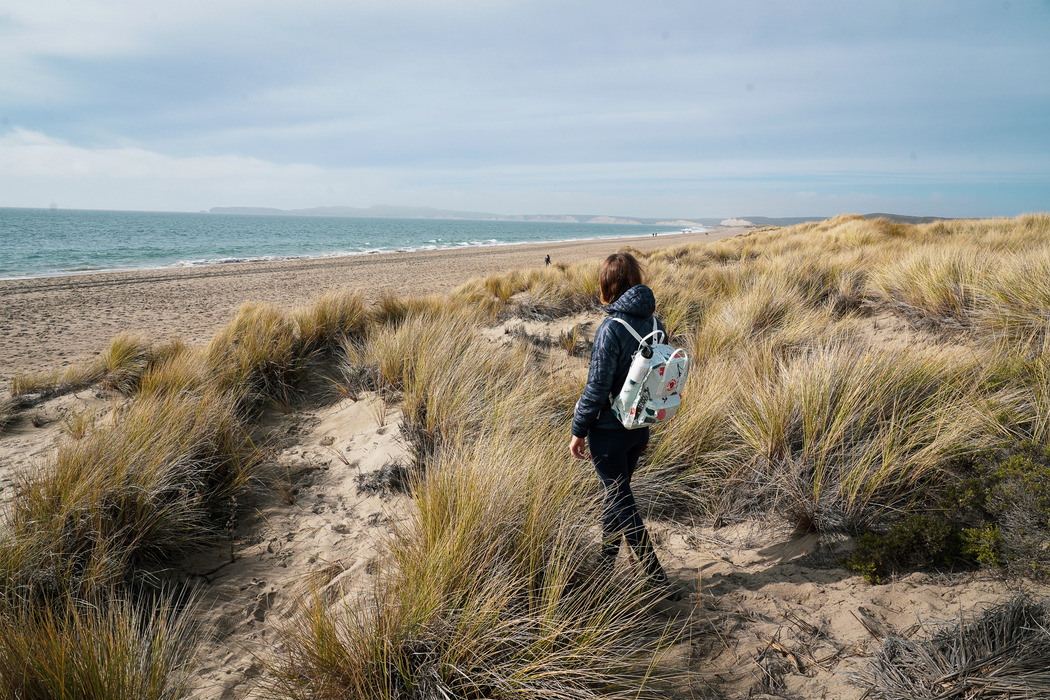 Woman walking on Limantour Beach in Point Reyes National Seashore 