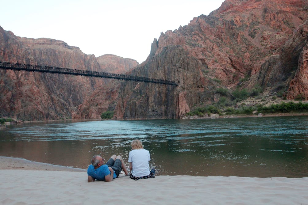 Two hikers relaxing at the riverside in Grand Canyon National Park 