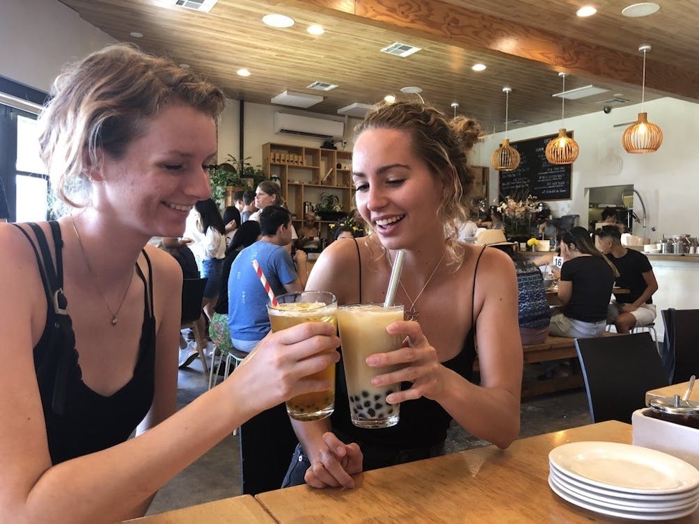 Two young women enjoying an iced tea at a cafe in Los Angeles