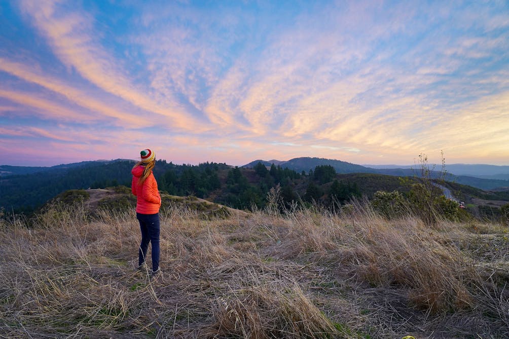 Woman watching a sunset atop Windy Hill at Windy Hill Preserve on the Peninsula