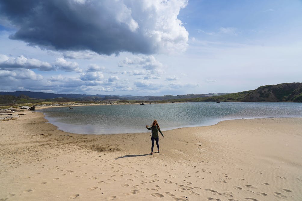 Woman standing at a lagoon at Pescadero Marsh Preserve