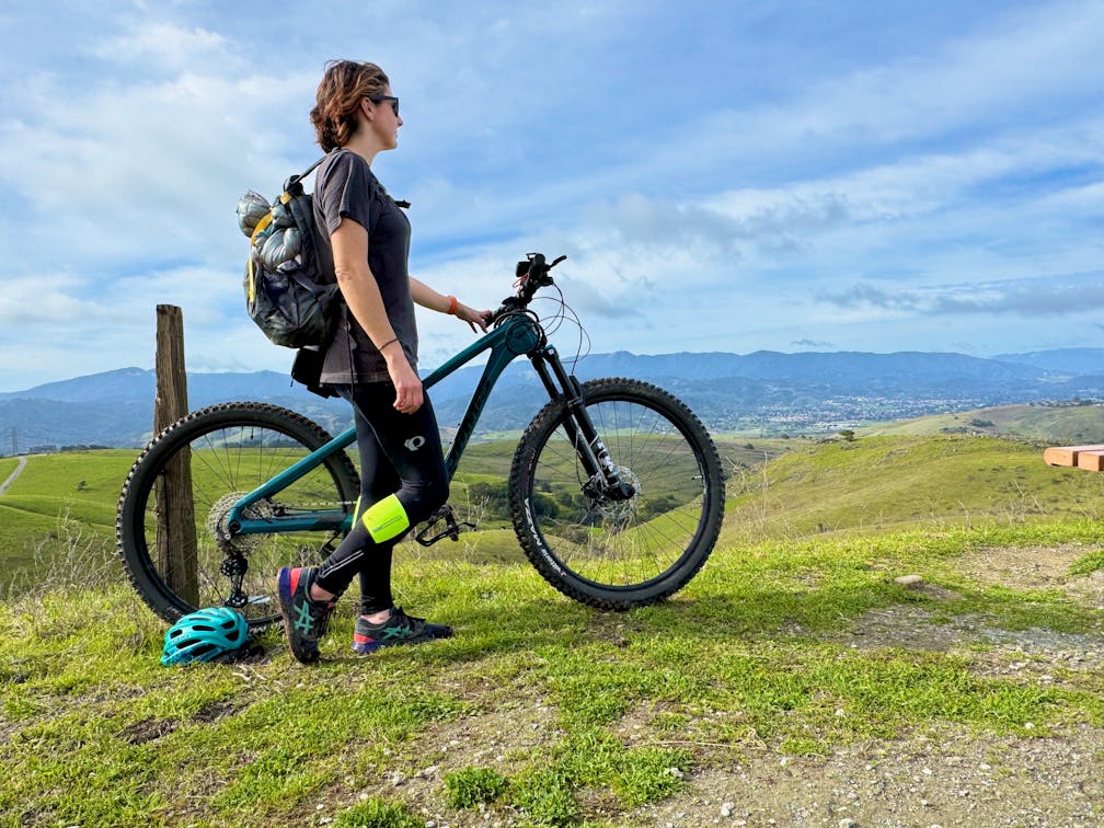 Woman on her mountain bike overlooking the scenery of the Santa Cruz mountains at San Jose's Santa Teresa County Park 