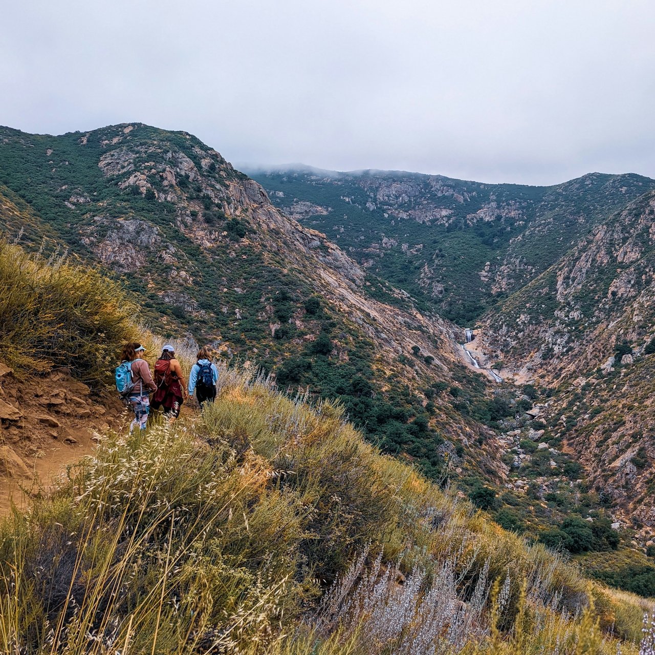 Hikers descending the canyon trail to reach Three Sisters Falls in Cleveland National Forest Southern Califronia