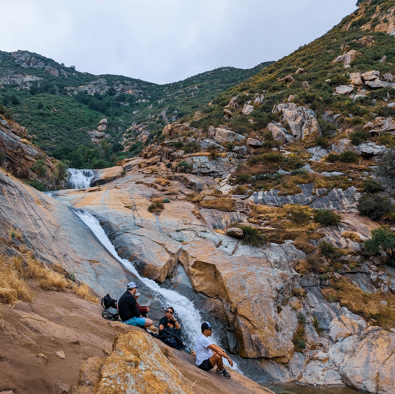 Hikers sitting on a rock slab near Three Sisters Falls in Cleveland National Forest close to Julian 