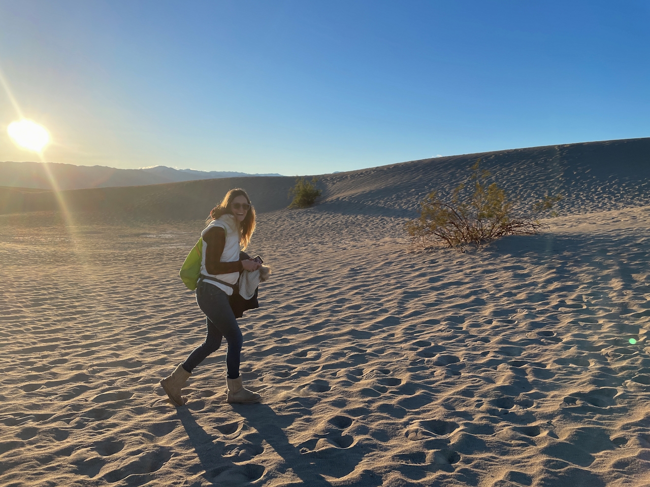 Woman walking to a sand dune at Mesuqite Flat Sand Dunes in Death Valley 