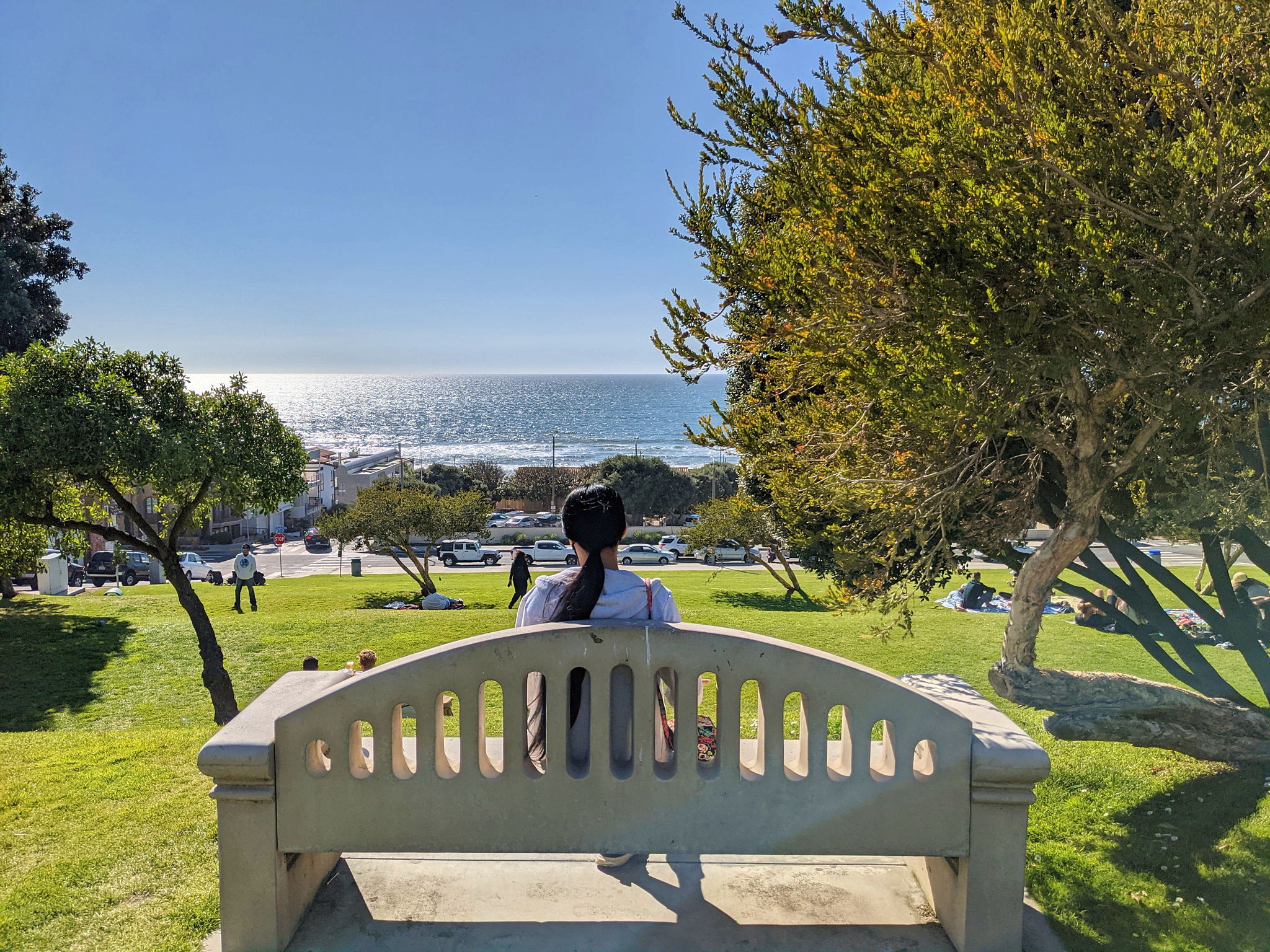 Woman sitting on a bench overlooking the ocean at Bruce's Beach in Manhattan Beach
