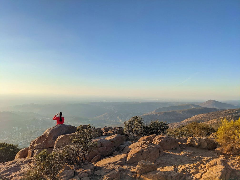 Woman viewing the scenery on a hike to the summit of Mount Cowles in San Diego 