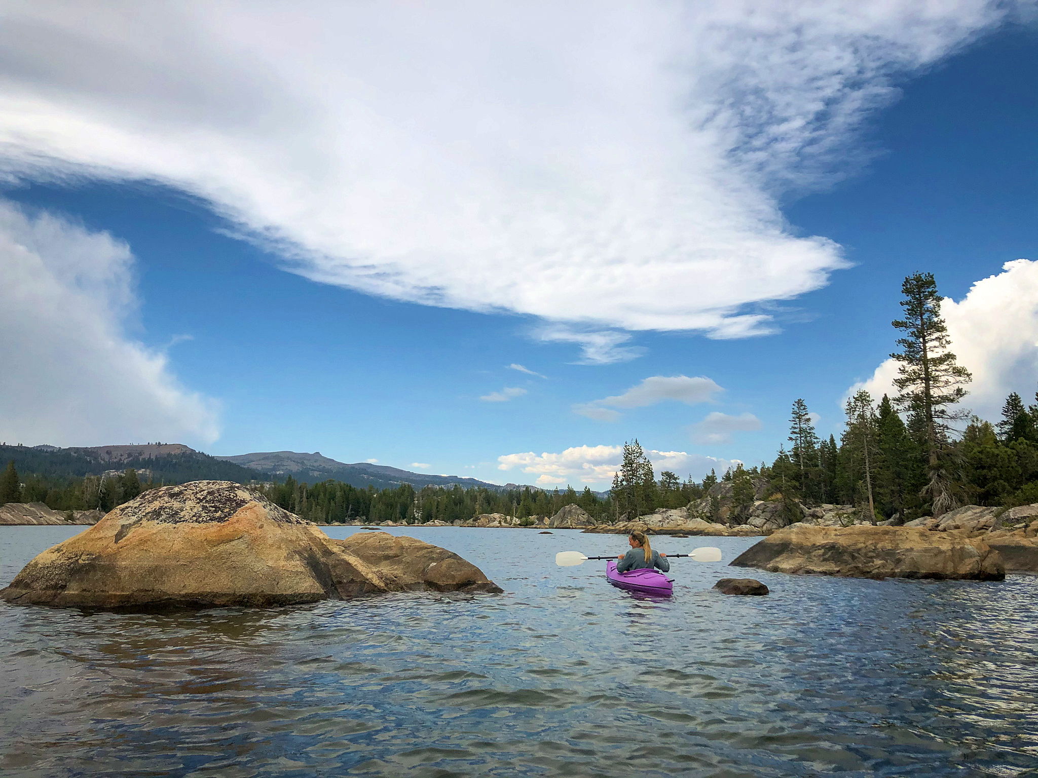 Woman kayaking at Utica Reservoir in Stanislaus National Forest 