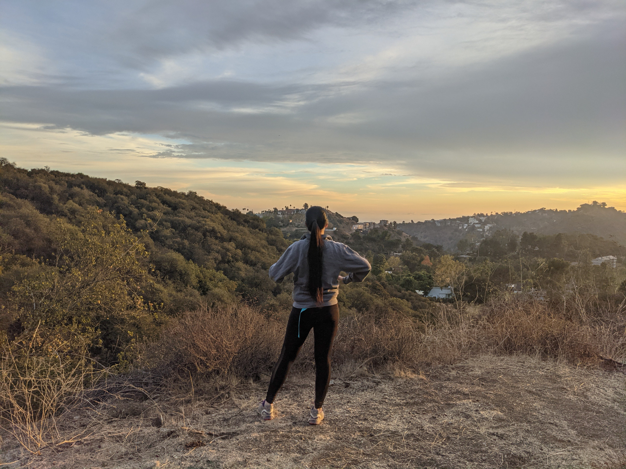Woman taking a photo with her phone at Briar Summit Preserve overlooking Los Angeles 