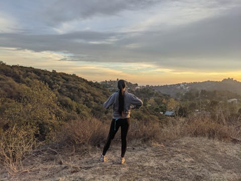 Woman taking a photo with her phone at Briar Summit Preserve overlooking Los Angeles 