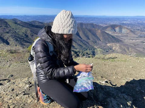 woman kneeling and signing peak book at Mount Olympia in Mount Diablo State Park 