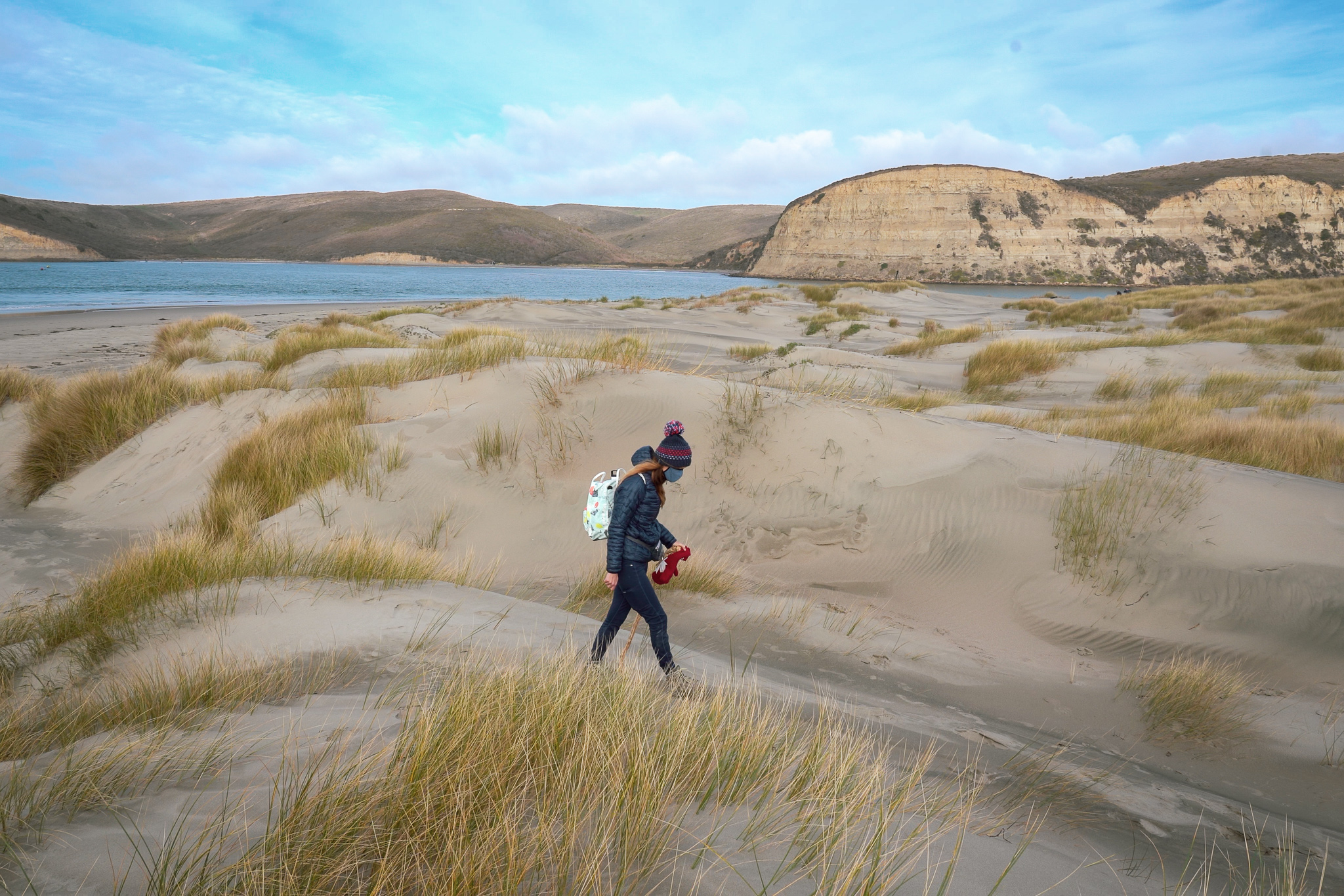 Woman walking on wide open beach in Pescadero