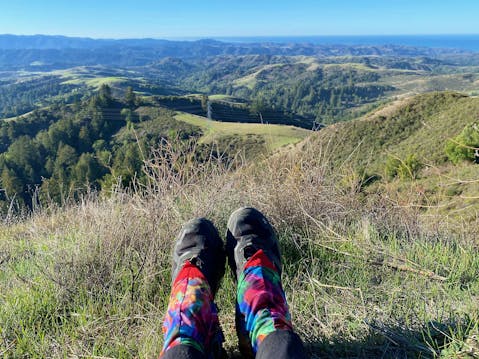 Hiking shoes pictured on person sitting at an overlook of the Santa Cruz Mountains at Upper La Honda Creek Preserve in the South Bay 