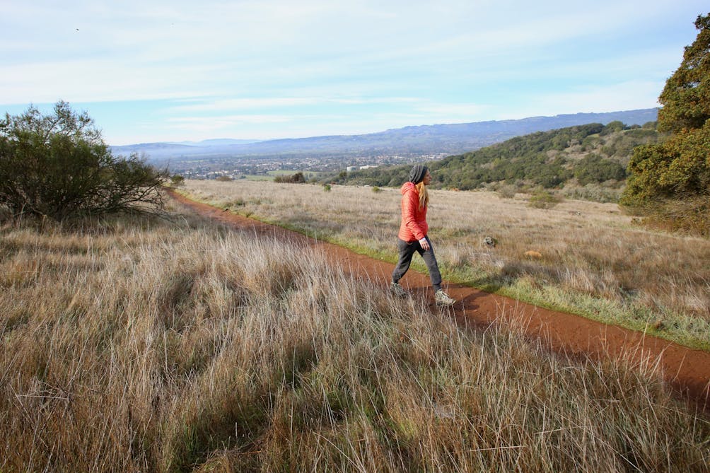 A woman walks the Sonoma Overlook Trail with views of Sonoma Valley below